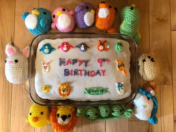 Several Woobles plushies surrounding a birthday cake