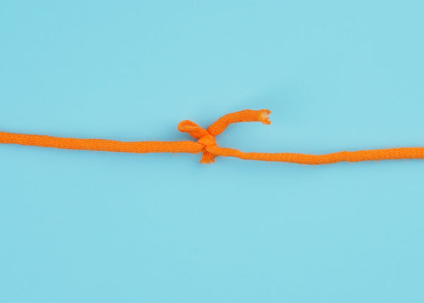 A knot on an orange tube-like yarn.