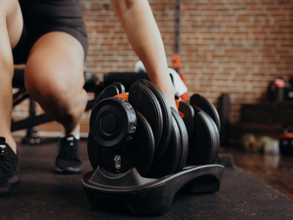 woman’s hand holding a adjustable dumbbell