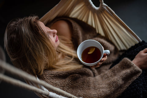 girl relaxing with a cup to glow chi tea