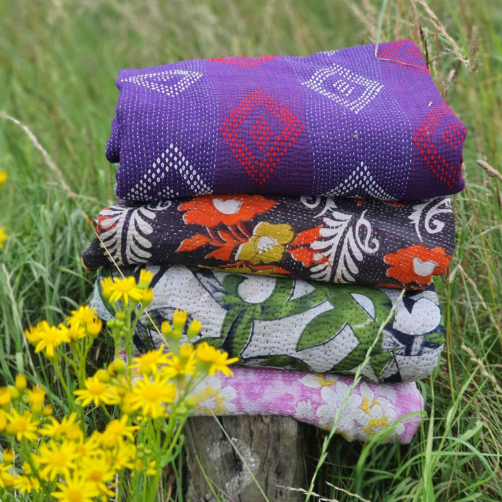 stack of vibrant vintage kantha quilts