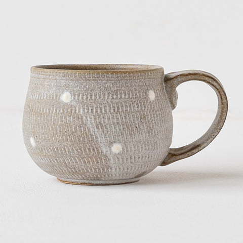 A coffee cup from Koishiwarayaki Oumei Kiln with beautiful rhythmically carved flying planes