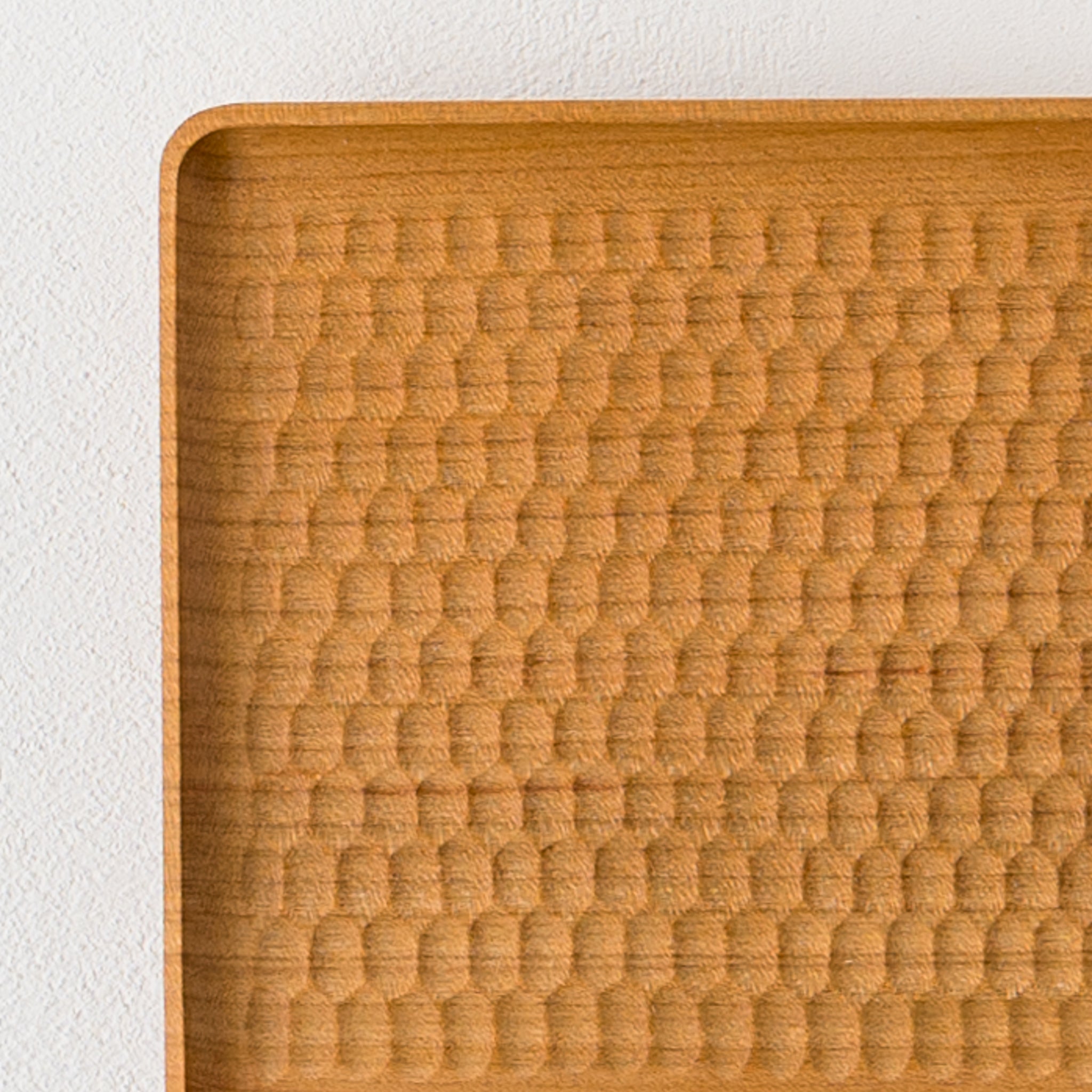 A corner coaster by Mr. Kazunori Gentakatsuka, a wood workshop with beautiful rhythmic bee carvings.