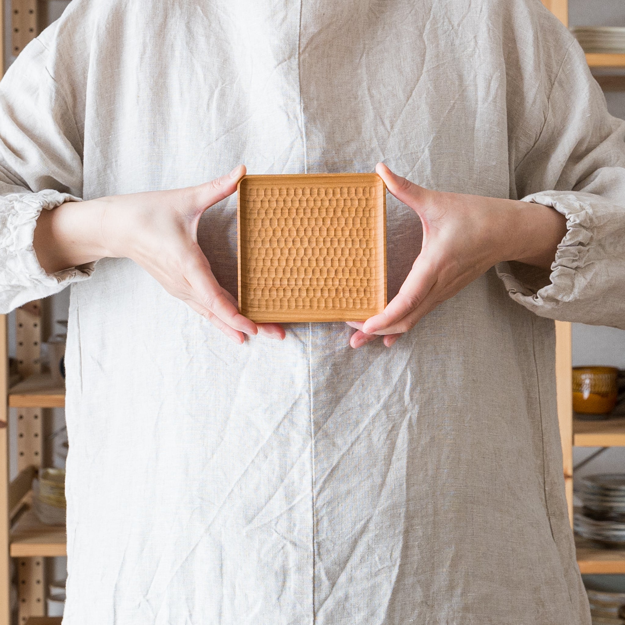 A corner coaster by Mr. Kazunori Gentakatsuka, a wood workshop that wraps the dining table with warmth.