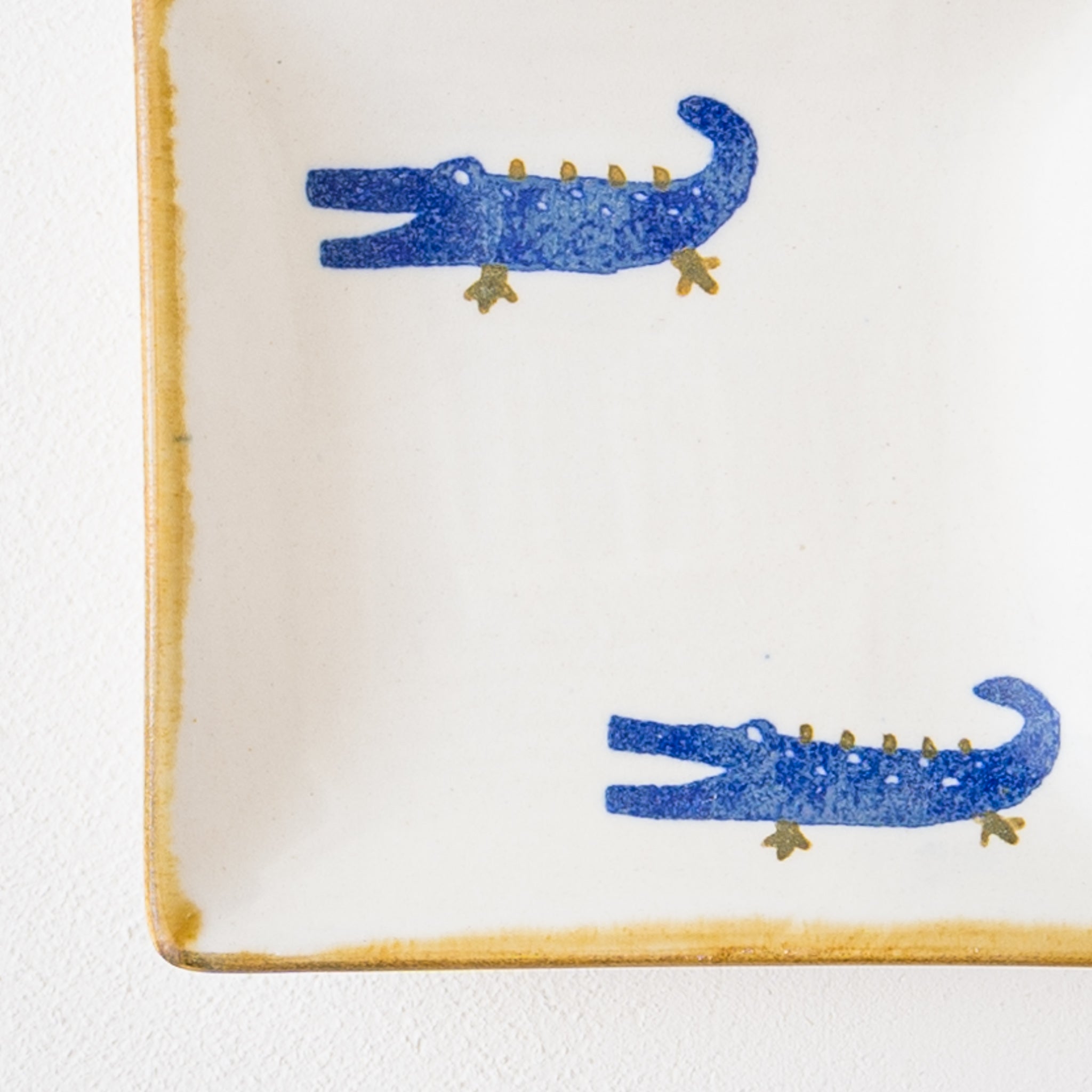 A small square plate from Yasumi Koubou that warms your heart with a cute Japanese paper-dyed crocodile