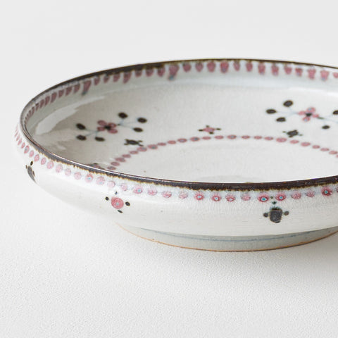 A 7-inch deep plate with a small flower pattern from a Tosai kiln with a beautiful indentation