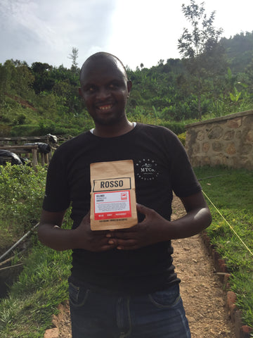 Kilimbi coffee farm worker holding a bag of Rosso coffee