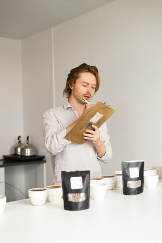 Cole Torode recording cupping results and coffee tasting notes