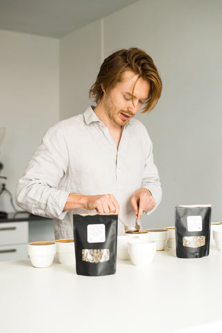 Cole Torode cupping coffee with cupping spoons