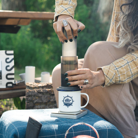 Plunging Aeropress coffee into camping mug 