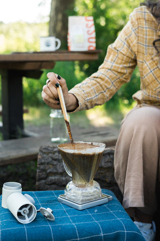 Stirring Clever Dripper coffee grinds with a stick