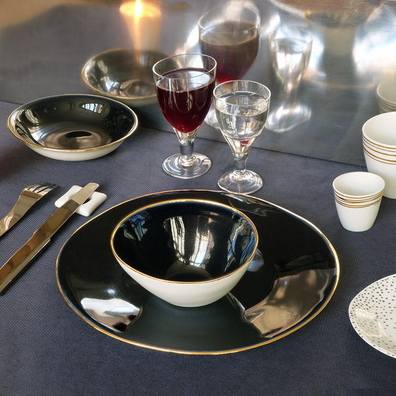table dressée avec vaisselle bleu nuit et liseré doré et verres à pied de forme irrégulière - tsé tsé