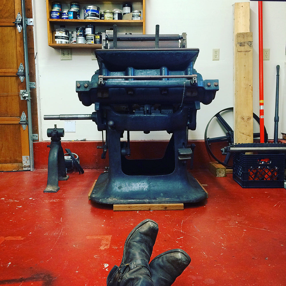 Colt's Armory printing press with boots in foreground