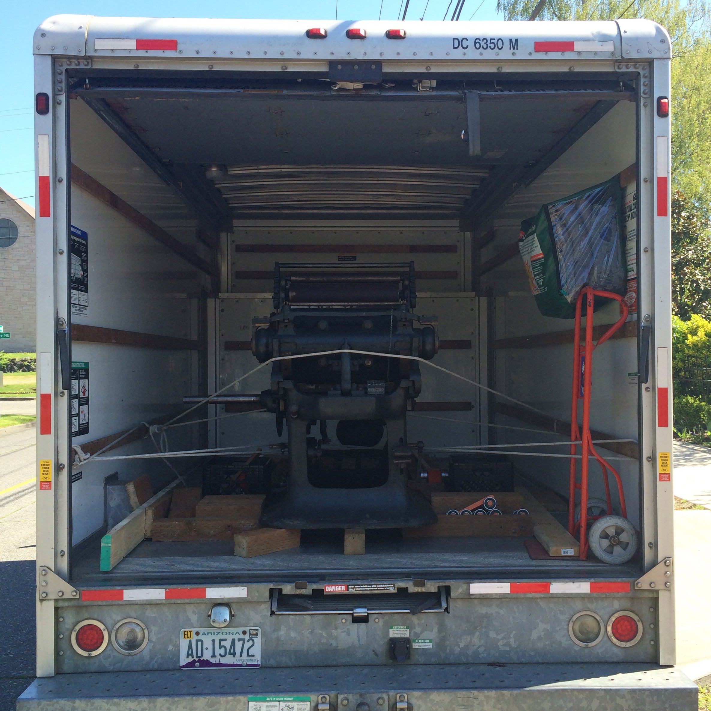 printing press tied down in the back of a uhaul truck