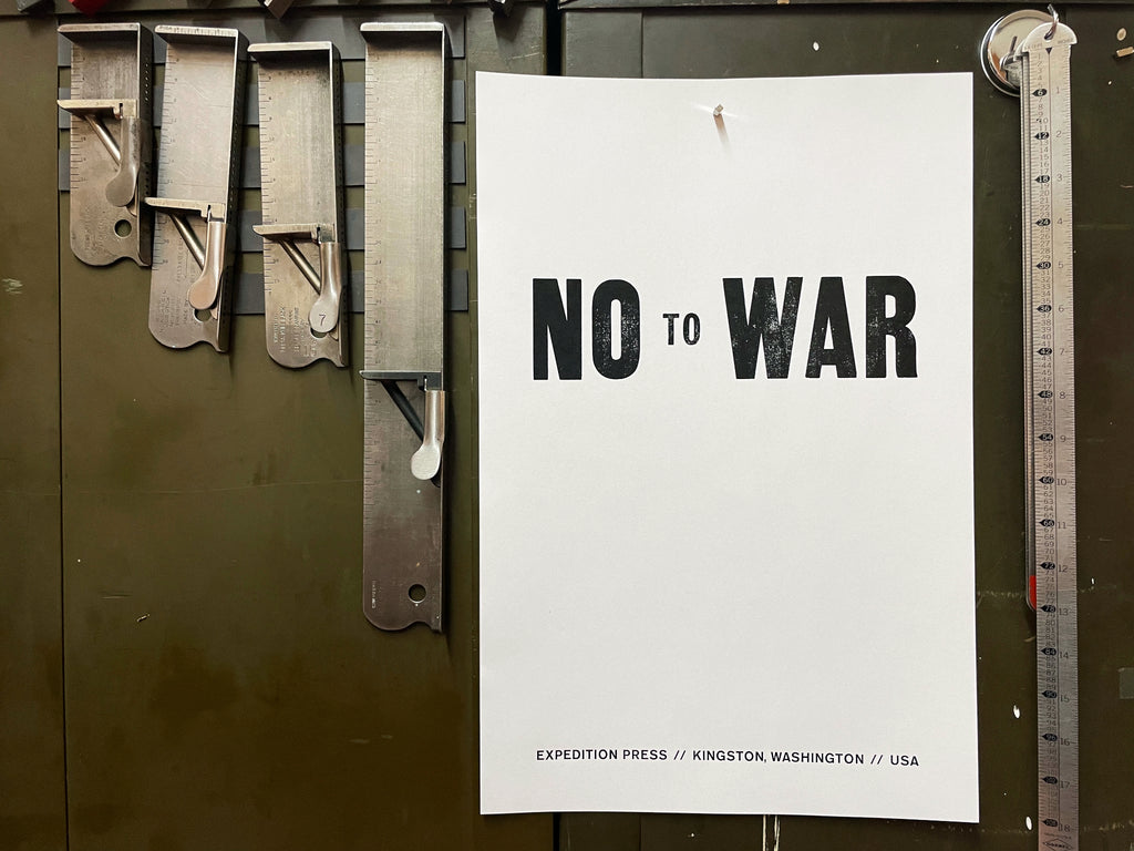 No to War poster, black and white, pinned to side of type galleys with composing sticks