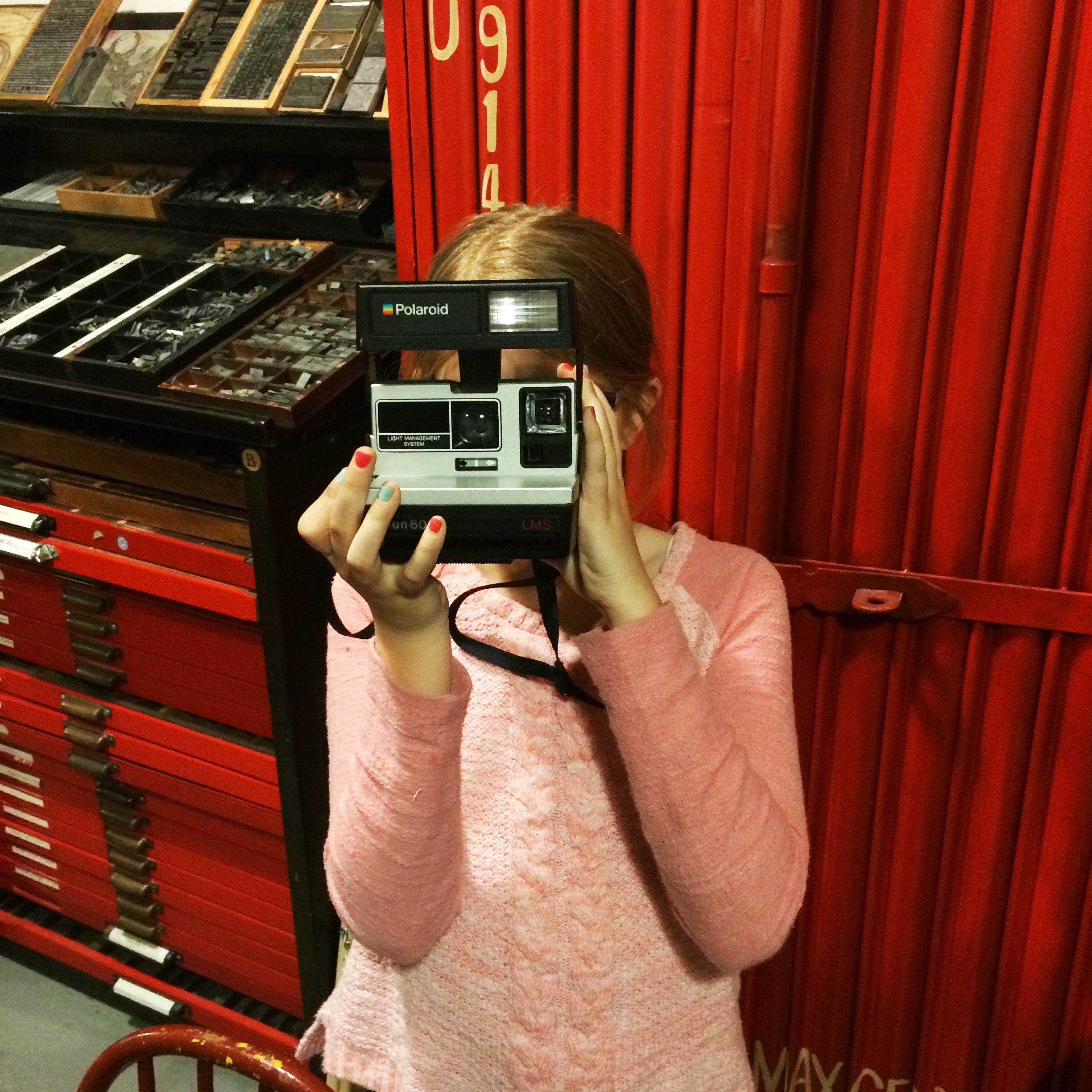 girl with polaroid camera in printshop