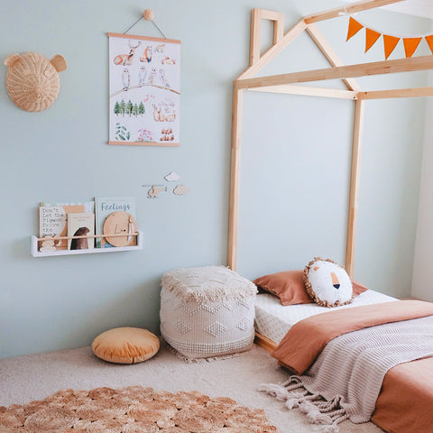 This is a toddler room with a bed and white with wood bookshelves