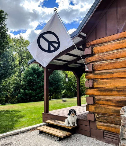 Peace Sign Flag flying on a log cabin