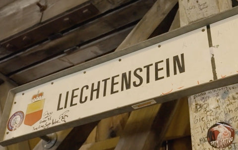 Yellow and red coat of arms for the princely house of Leichtenstein on a sign at the border with Switzerland