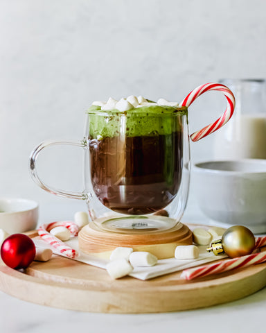 photo of hot chocolate made with matcha green tea powder, with candy canes and Christmas globes in the background