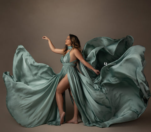 brunette model in a studio wearing a silky dress in azur color