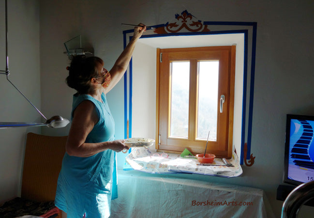 Home owner took this photo of artist Kelly Borsheim painting on his wall in the dining room.