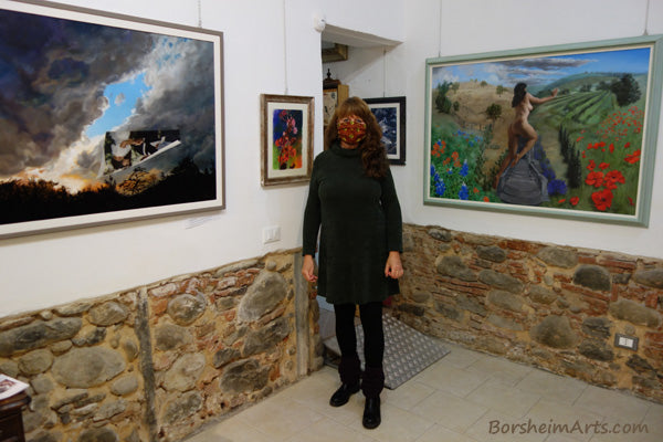 Artist Kelly Borsheim stands between two of her paintings in solo show:  New Years's Eve and Persefone