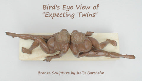 bird's eye view of the sculpture of twin women sitting back to back on a long piece of Texas limestone... art by Kelly Borsheim.