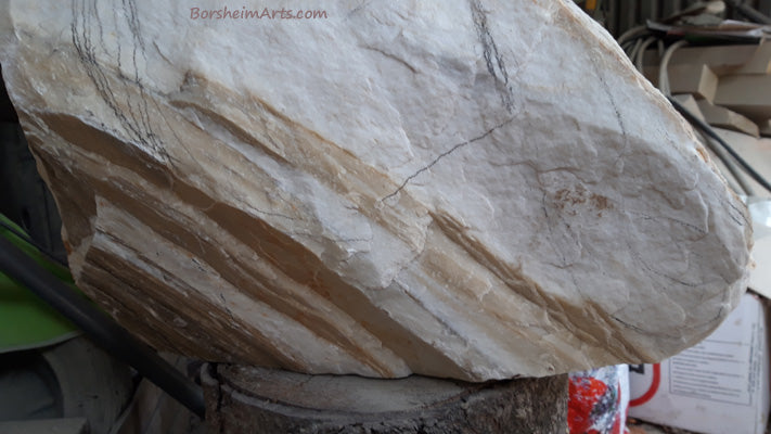 Good view of the back side with layers of golden rock alternating with white marble