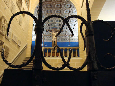 iron gate detail frames another crucifix in the blue walls of Bardini Museum Florence Italy