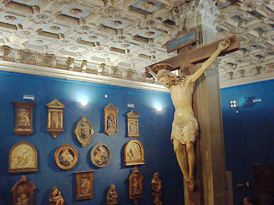 crucifix in a blue room art filled walls and hand carved painted ceiling Bardini Museum Florence Italy