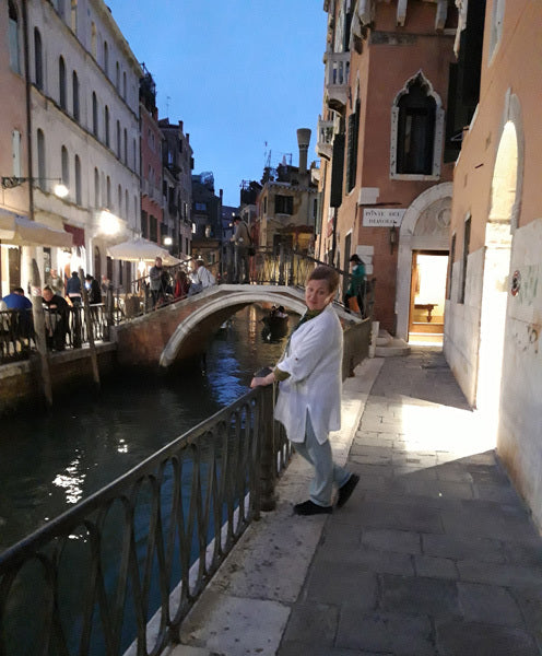 Dilya Arapove in Venice, Italy near Canal with Bridge in Background