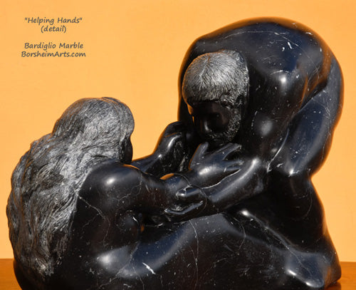 Detail of marble carving Helping Hands man helps woman to her feet