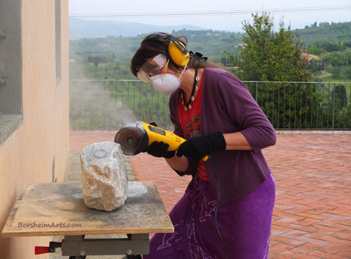 Artist Kelly Borsheim starts on the stone carving When Atlas Tires with a diamond disc cutting into the marble from Carrara, Italy