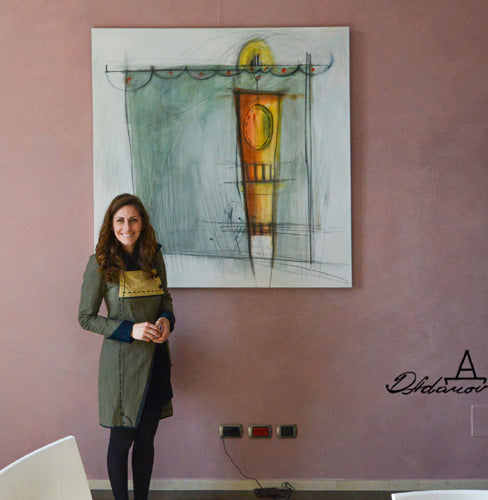 Artist Dragana Adamov poses in her designed and hand-sewn dress in front of her large abstract painting Aphrodite.