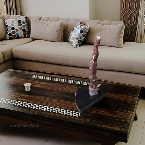 marble carving of an abstracted male diver just as he enters the water sits on a coffee table as a focal point in the living room art