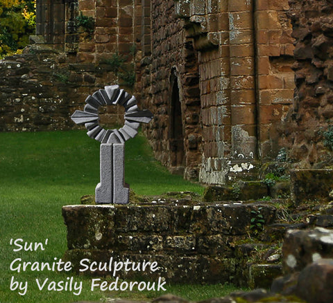 Sun, an abstract granite sculpture by Vasily Fedorouk, shown in a garden with brick walls