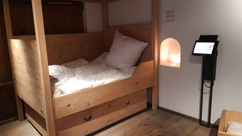 simple wooden bed shown with drawers underneath the straw mattress that were for young children to sleep in