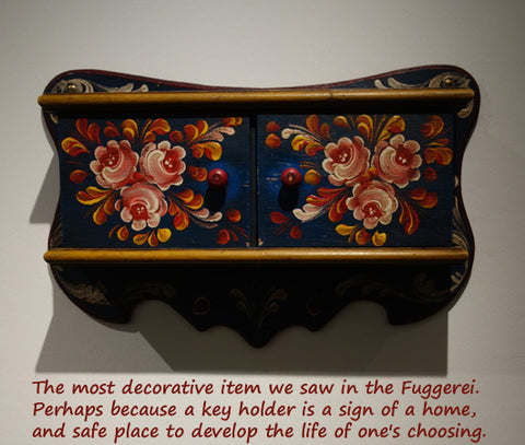 this decorative box painted in German floral designs hangs on the wall as a key chest