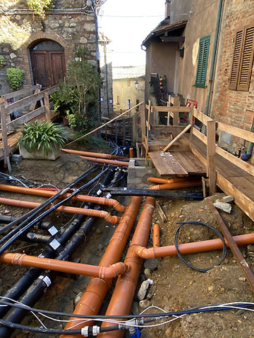 open streets for town plumbing to using natural hot springs to heat homes Chiusdino, Tuscany, Italy