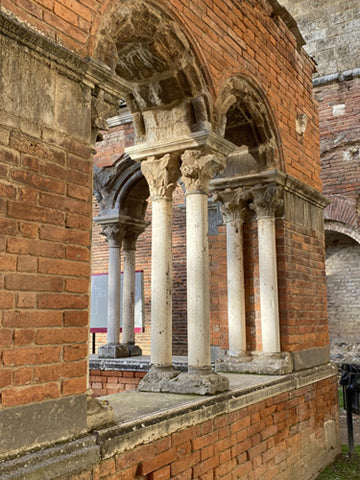 West entrance with small pillars of marble in brick arches to the Abbey of San Galgano, Siena, Tuscany