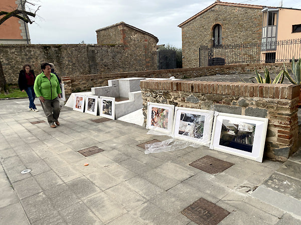 Curator walks along a wall of unloaded photos to insure she wants them in the exhibit