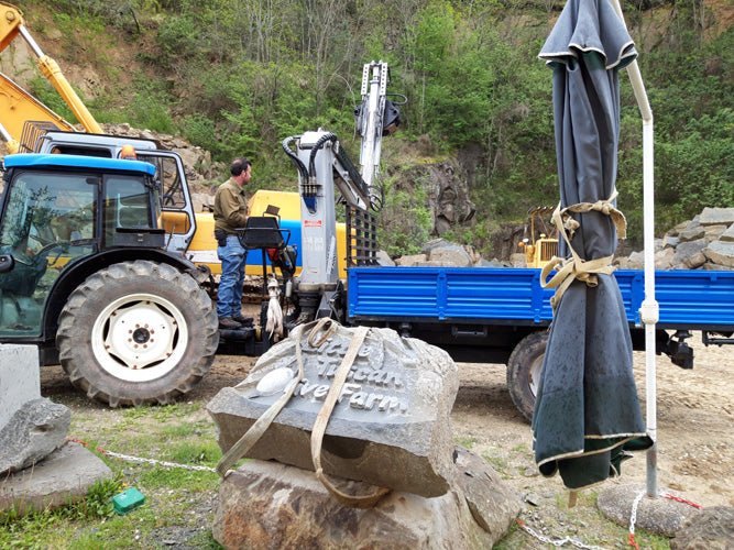 Truck with moving arm to lift and move heavy stone carving from quarry to its new home in Tuscany, Italy.