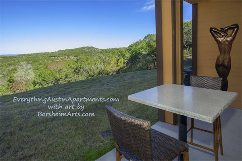Ten, a large wall hanging figure bronze sculpture looks great in this outdoor terrace overlooking the green hills of Austin, Texas, rental apartments from Everything Austin Apartments