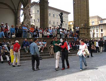 Mime gReY performs in front of the Loggia dei Lanzi in Florence Italy by Pio Fedi sculpture