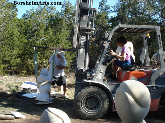 Artist Driving a Fork Lift Moving a Marble Statue into a Sculpture Garden