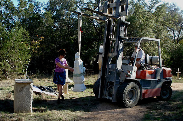 Artist Driving a Fork Lift Moving a Marble Statue into a Sculpture Garden