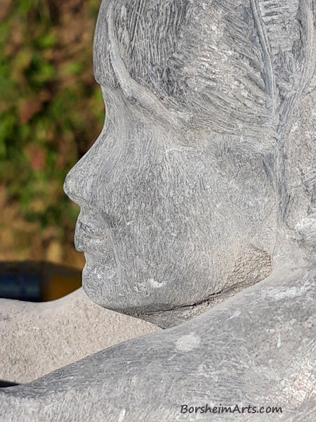 close up of profile of woman's face in stone carving Helping Hands