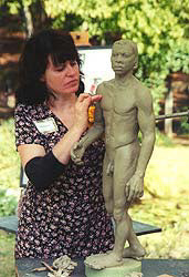 Artist Kelly Borsheim creates a male figure in clay for bronze casting.