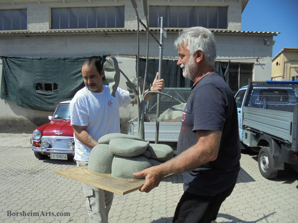Nori and foundrymen carry clay sculpture into mold making room Pietrasanta